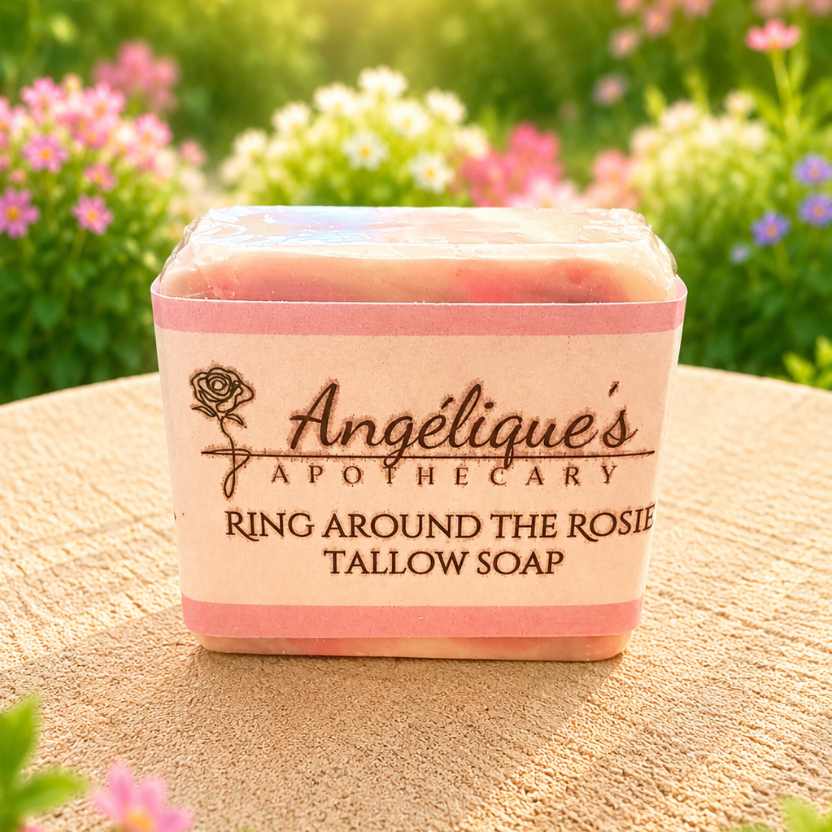 Tallow soap in a pink container with 'Angélique's Apothecary' branding, set against a natural background with flowers.